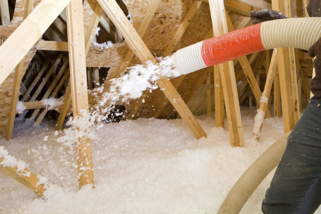 An installer adding blown in insulation to an attic